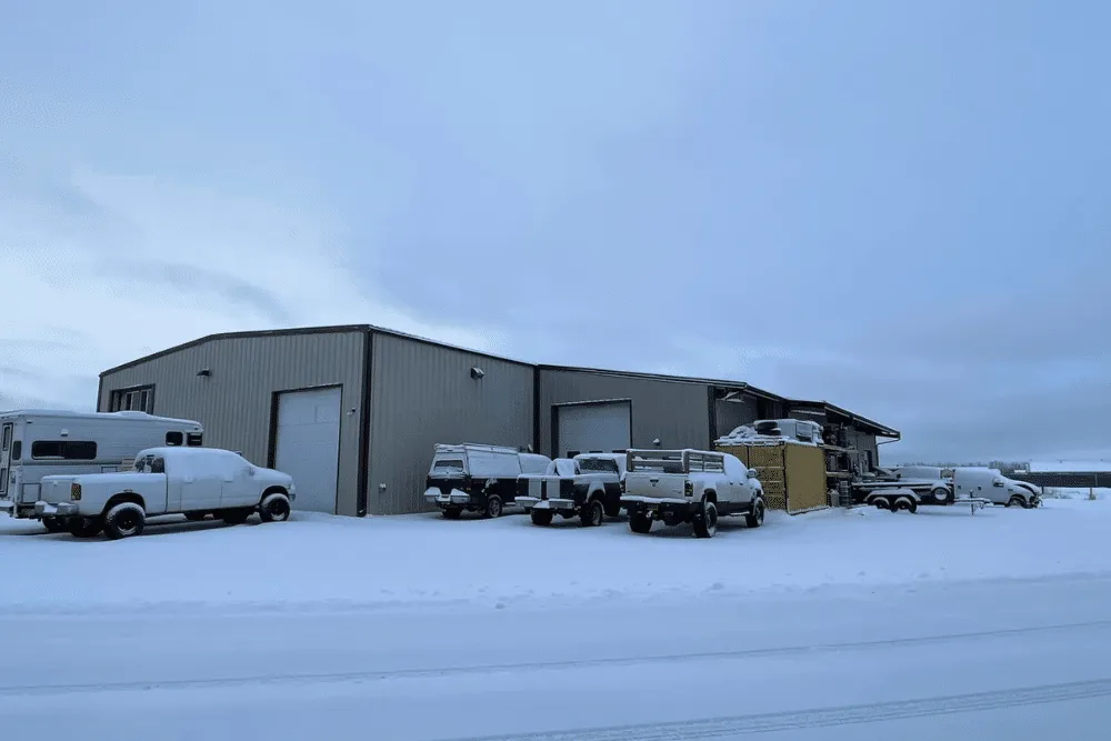 cold weather diesel, diesel repair in Palmer, AK at 1023 Diesel & Fleet. Snow-covered trucks outside auto repair shop in winter conditions.